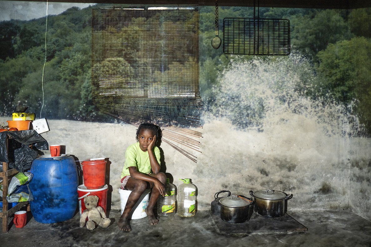 Inhaca.Atália Almeida, 8 anni, accanto alla sala-cucina di casa sua. Va a scuola e aiuta sua madre nei campi di manioca