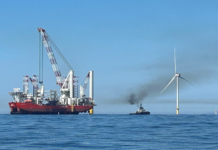 Eolico offshore: il Dipartimento dell’Interno USA riesamina l’approvazione di Revolution Wind due navi navigano vicino a una pala eolica off shore